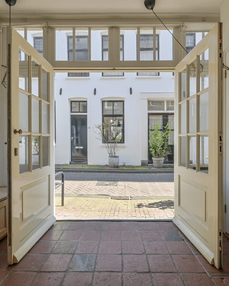 Openslaande deuren van een Amsterdamse woning met zicht op de straat